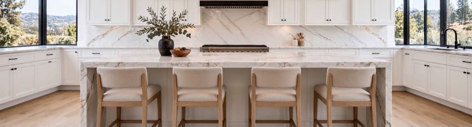 Kitchen with a marble waterfall island, four bar stools and full-height stone backsplash, installed by Absolute Stone Design TN